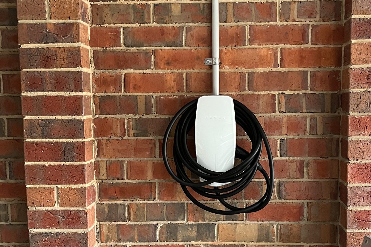 Tesla Wall Connector installed on a brick wall with a straight conduit run, by SALTD Electrical